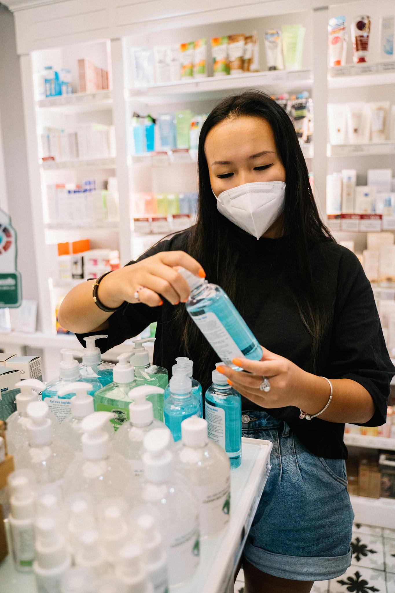 Woman in Black Shirt Holding A Bottle Of Hand Sanitizer